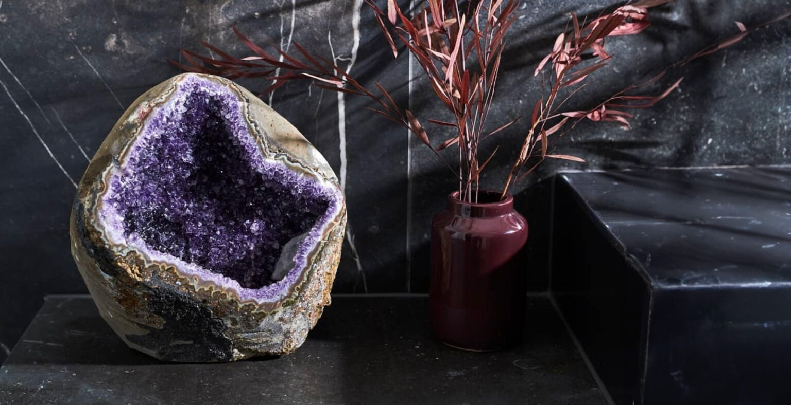 En stor ametyst-geode, på en sort baggrund.