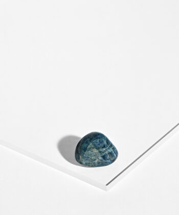 Poleret Blå Apatit i dybe petroleumsblå og petroleumsgrønne farver på hvid baggrund