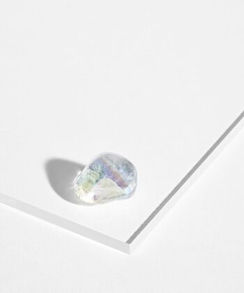 Meget magisk aura kvarts med regnbue nuancer på hvid baggrund.