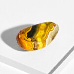 Poleret Bumblebee Jasper sten i gule farver på hvid baggrund