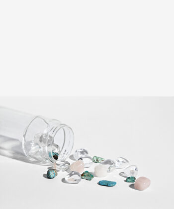 Krystalsæt som ligger i en vandflaske på en hvid baggrund. klar kvarts