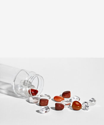 Krystalsæt som ligger i en vandflaske på en hvid baggrund. Klar kvarts