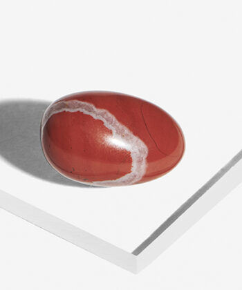 Lommesten i rød Jaspis på hvid baggrund