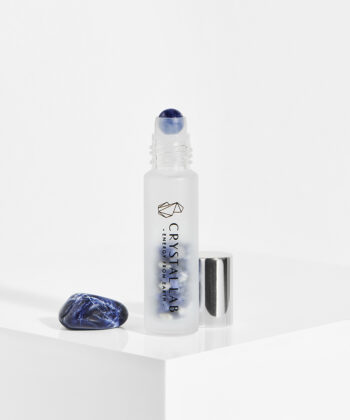 En hvid baggrund med en roll on med minikrystaller. Blå sodalit