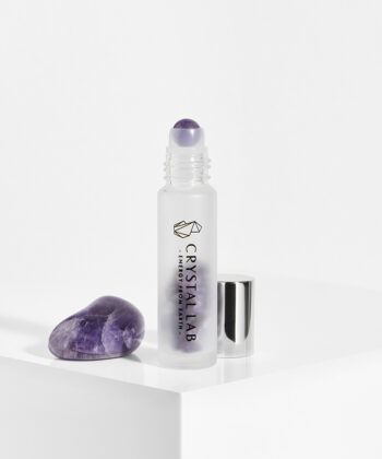 En hvid baggrund med en roll on med minikrystaller. Lilla Ametyst