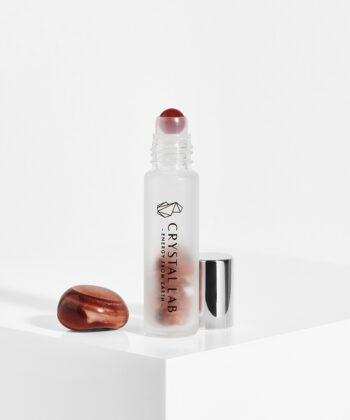 En hvid baggrund med en roll on med minikrystaller. Orange Karneol