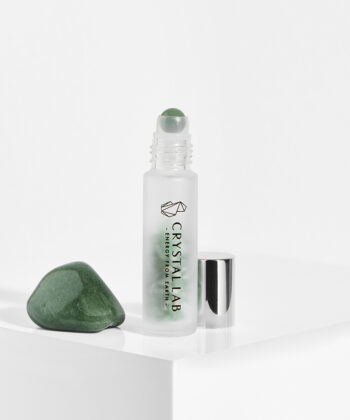 En hvid baggrund med en roll on med minikrystaller. Grøn Aventurin