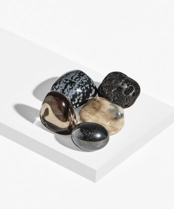 Krystalsæt på hvid baggrund. 3 sorte sten og to brune sten