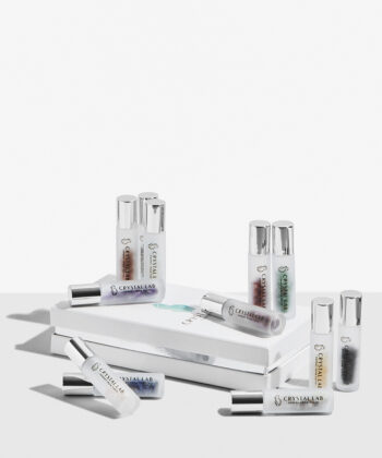 Hele sættet af roll on med krystaller som ligger på en æske. Ligger på en hvid baggrund