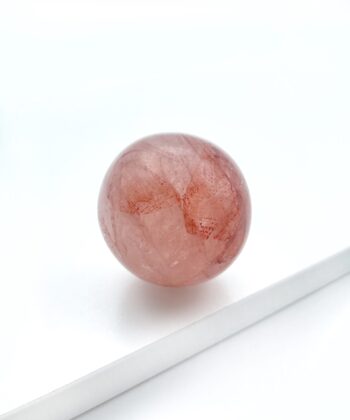 rødlig krystalkugle på hvid baggrund