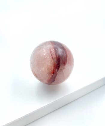 rødlig krystalkugle på hvid baggrund