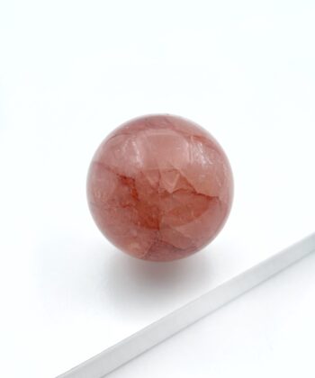 rødlig krystalkugle på hvid baggrund