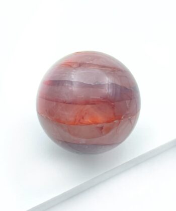 rødlig krystalkugle på hvid baggrund