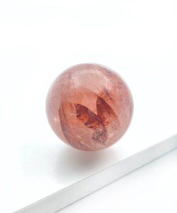 rødlig krystalkugle på hvid baggrund