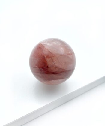 rødlig krystalkugle på hvid baggrund