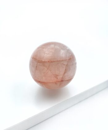 rødlig krystalkugle på hvid baggrund