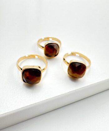 guld farvet ring med brun sten på hvid baggrund