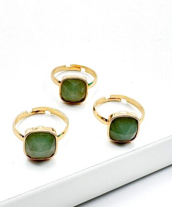 guld farvet ring med grønsten på hvid baggrund