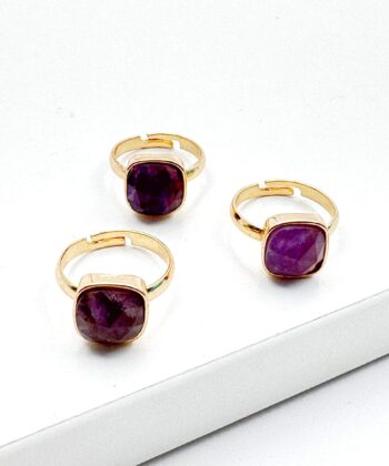 guld farvet ring med lilla sten på hvid baggrund