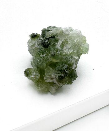 Grønt druzy rå krystalstykke på hvid baggrund