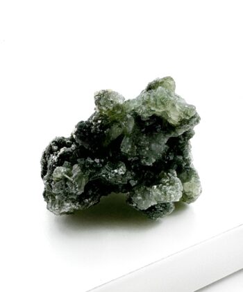 Grønt druzy rå krystalstykke på hvid baggrund