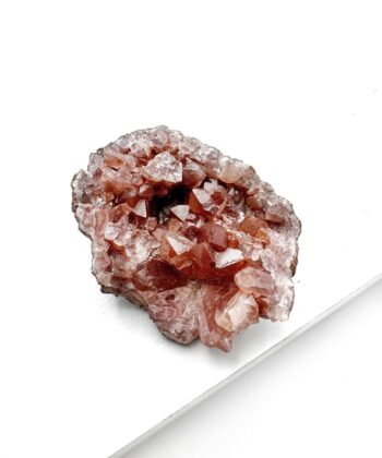 lyserødt druzy rå krystalstykke på hvid baggrund