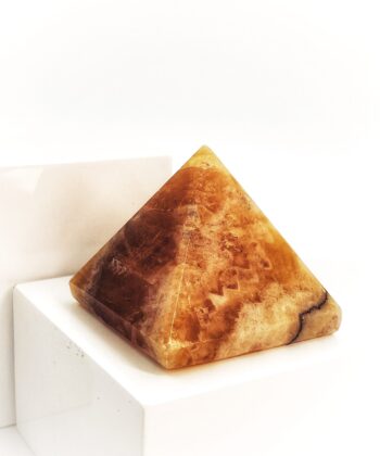 Gylden krystalpyramide på hvid baggrund