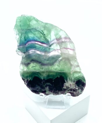 Smuk rå fluorit krystal i lilla hvid og grøn på hvid baggrund