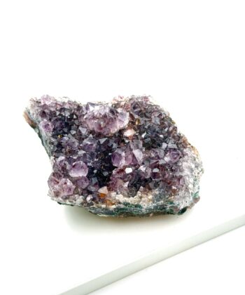 Rå lilla ametyst krystal med brune detaljer på hvid og sort bund