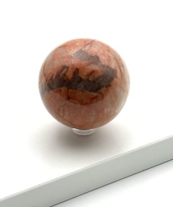 Rosa krystalkugle med grå detaljer på hvid baggrund