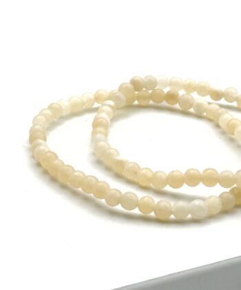 To lysegule armbånd med halvædelsten på hvid baggrund