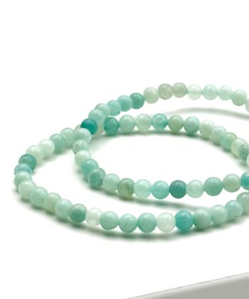 To turkise armbånd med halvædelsten på hvid baggrund