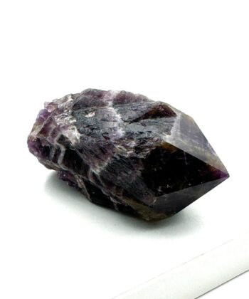 Dyblilla rå krystal med hvide detaljer og poleret spids på hvid baggrund