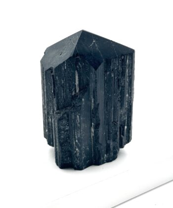 Sort rå krystal med poleret spids på hvid baggrund