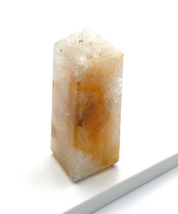 Gyldent og råhvidt krystaltårn på hvid baggrund