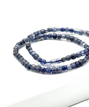 Elastik armbånd med facetterede stenperler i blå og grå nuancer