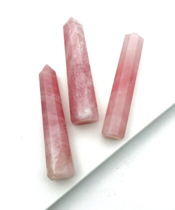 Tre lyserøde søjler i halvædelsten på hvid baggrund