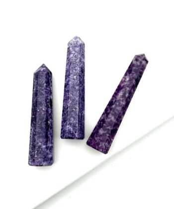 Tre blålilla søjler i halvædelsten på hvid baggrund