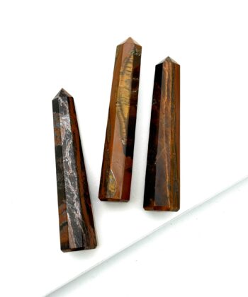 Tre brune søjler i halvædelsten på hvid baggrund