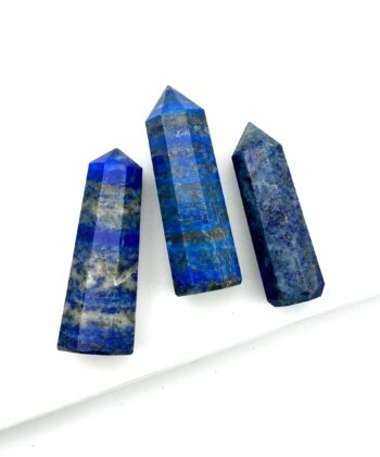 Tre kongeblå søjler i halvældelsten med grå og sølvfarvede detaljer på hvid baggrund