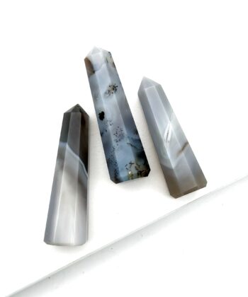 Tre grå søjler i halvædelsten med sorte og brune detaljer på hvid baggrund