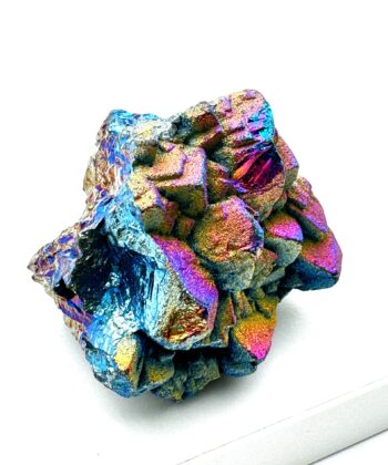 Metallisk regnbuefarvet rå krystal på hvid baggrund