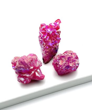 Tre pink metalliske rå krystaller