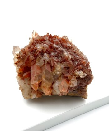 Rå krystal i gyldne og rødlige farver på hvid baggrund