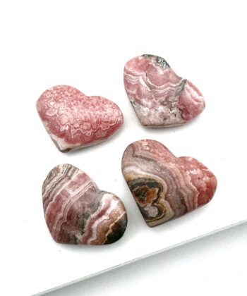 Fire rosa hjerter i halvædelsten med brune og hvide detaljer på hvid baggrund