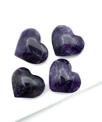 Fire lilla hjerter i halvædelsten på hvid baggrund