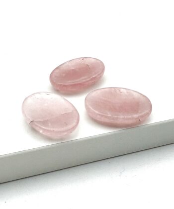 Tre lyserøde worrystones i rosenkvarts på hvid baggrund