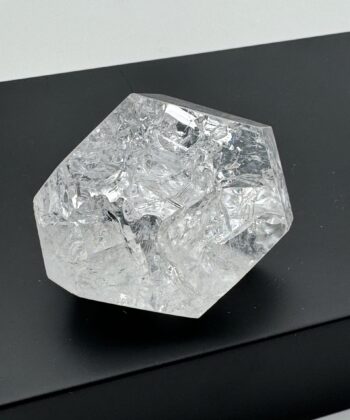 Mangekantet semitransparent krystal på sort baggrund