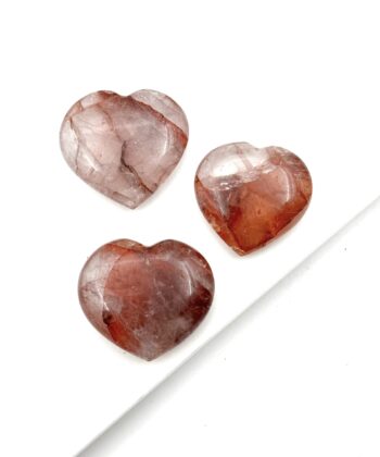 Tre polerede hjerter af halvædelsten i rødbrune og hvidlige nuancer