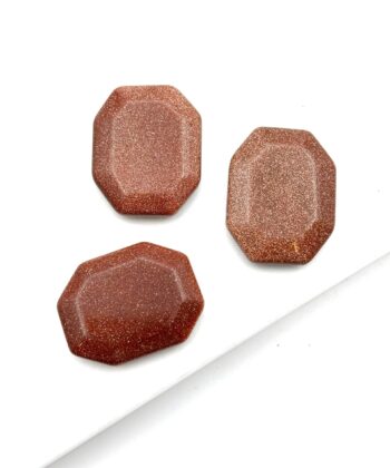 Polerede ottekantede rødbrune sten med gyldent glimmerskær